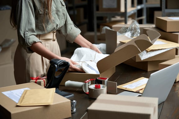 Woman Packing E-commerce Purchases for Shipping - Smart Warehousing
